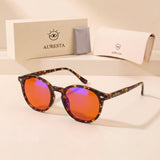 Hazel tortoise round blue light glasses with orange lenses beside the Auresta box, case and cleaning cloth