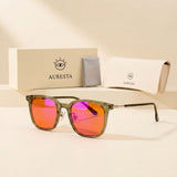 Olive blue light glasses with orange lenses beside the Auresta box, folding case and cleaning cloth