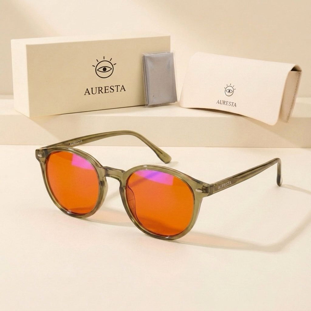 Vesper blue light glasses in sage green TR90 resting beside the cream Auresta box, case and cloth